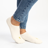 Natural cotton no-show invisible socks worn with blue jeans on a white background