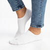 White organic cotton no see invisible socks worn with blue jeans on a white background